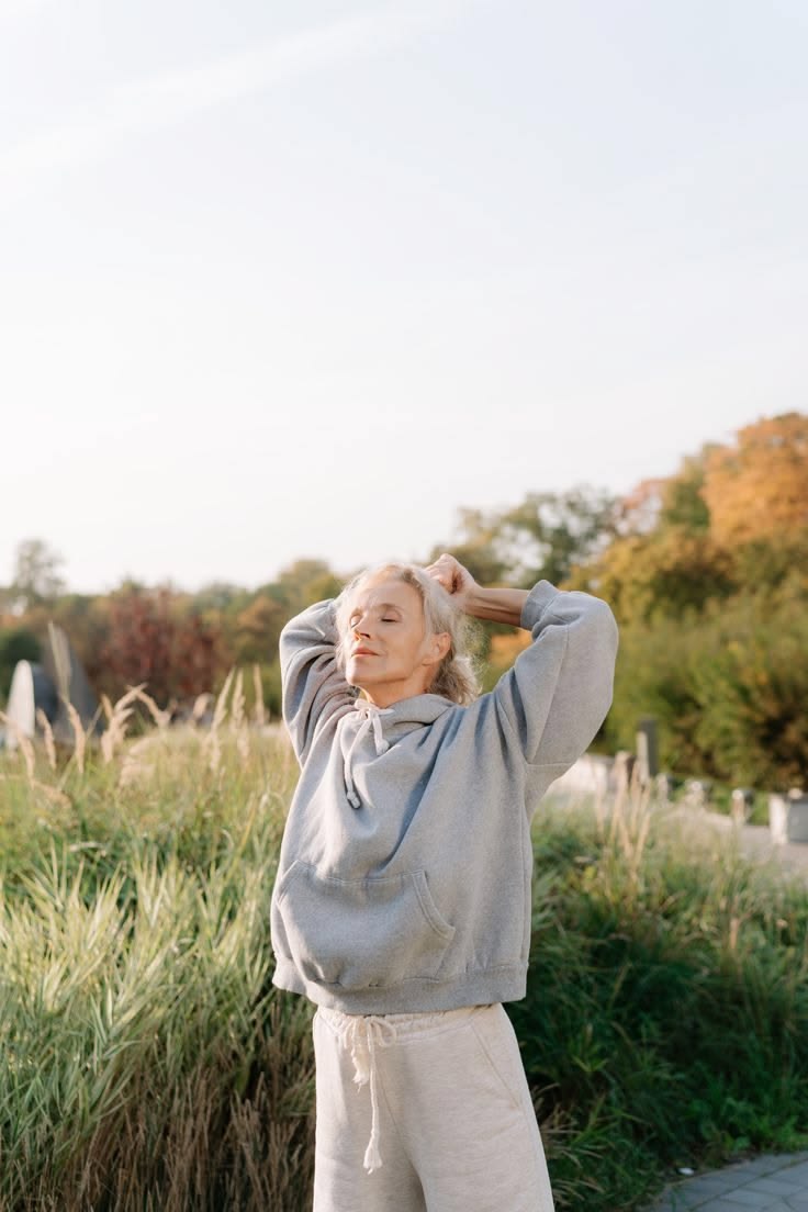Vrouw rekt zich uit in de herfstzon